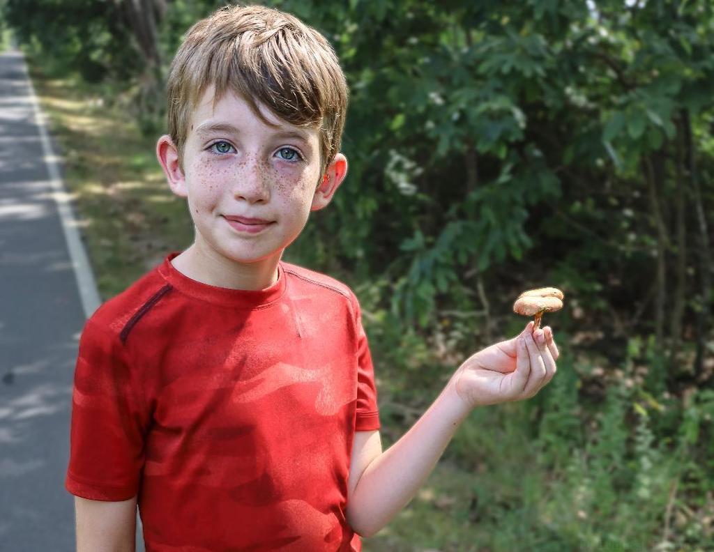 student poses with mushroom